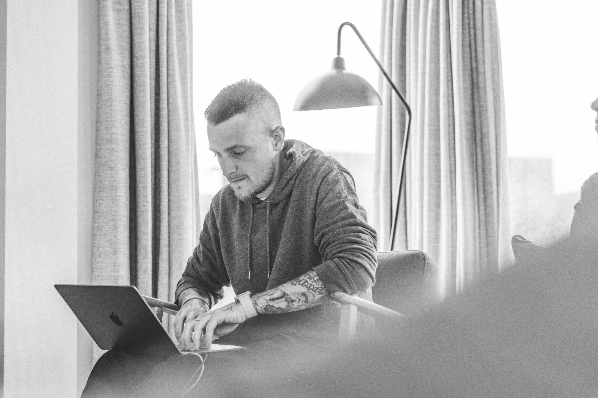 Daniel Boberg arbeitet am Laptop, schwarz-weiß