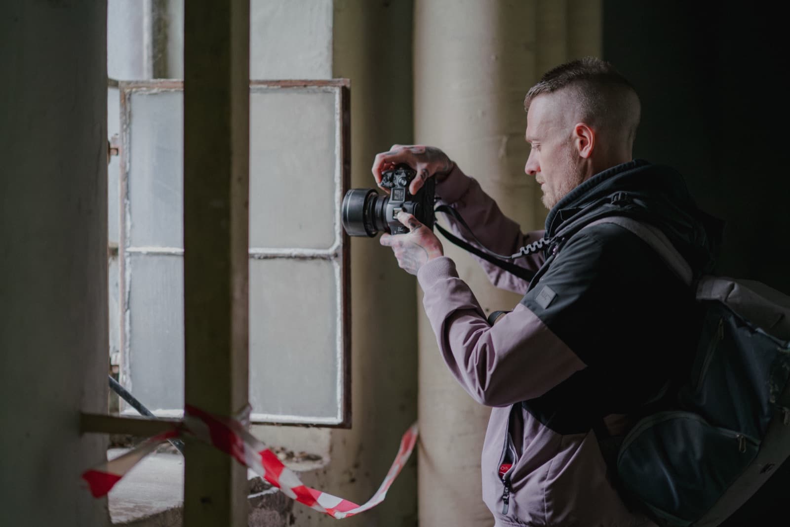 Daniel Boberg fotografiert am Fenster einer verlassenen Fabrik