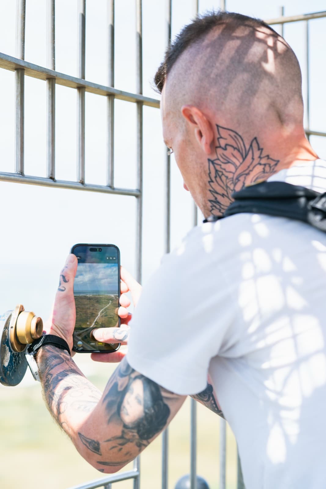 Daniel Boberg fotografiert mit dem Smartphone durch ein Gitter