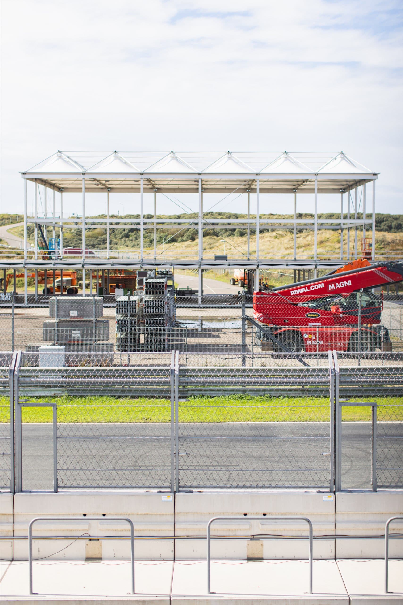 Tribüne und rote Fahrzeuge hinter dem Zaun am Circuit Zandvoort