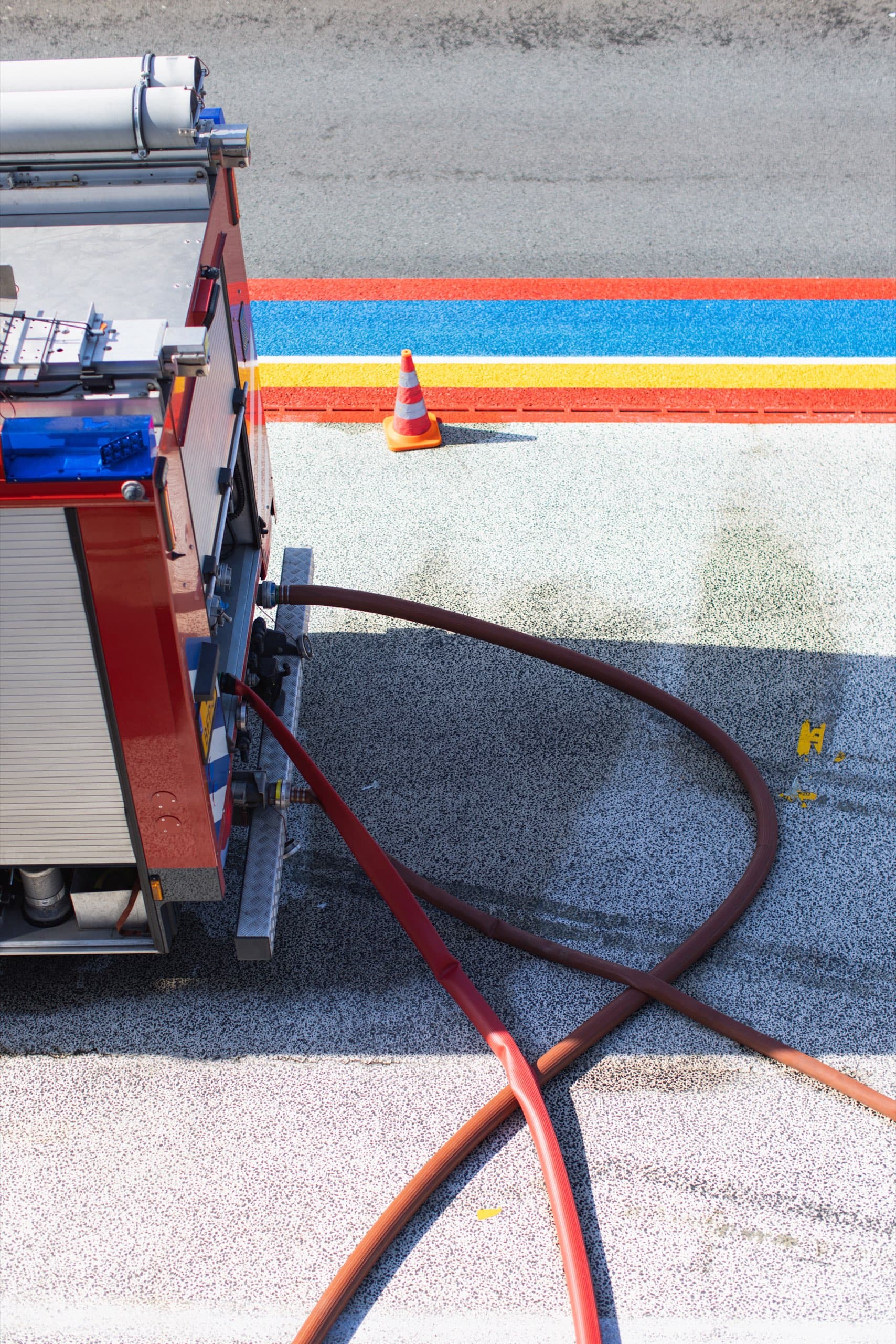 Feuerwehrfahrzeug mit Schlauch an der Boxengasse