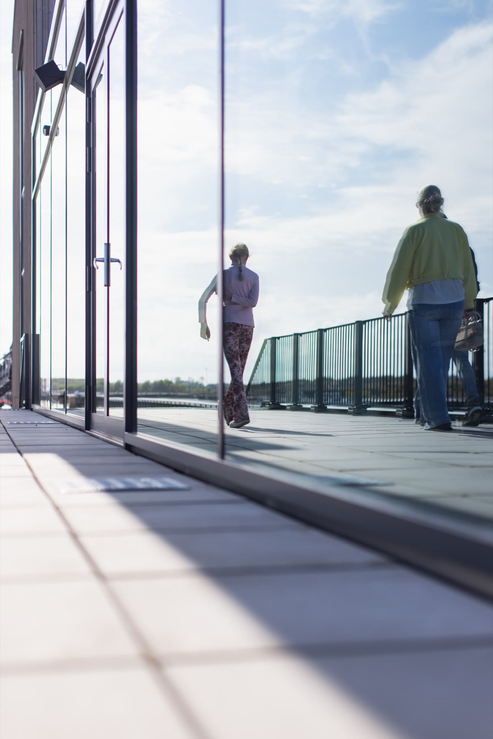 Menschen auf der verglasten Terrasse über der Strecke