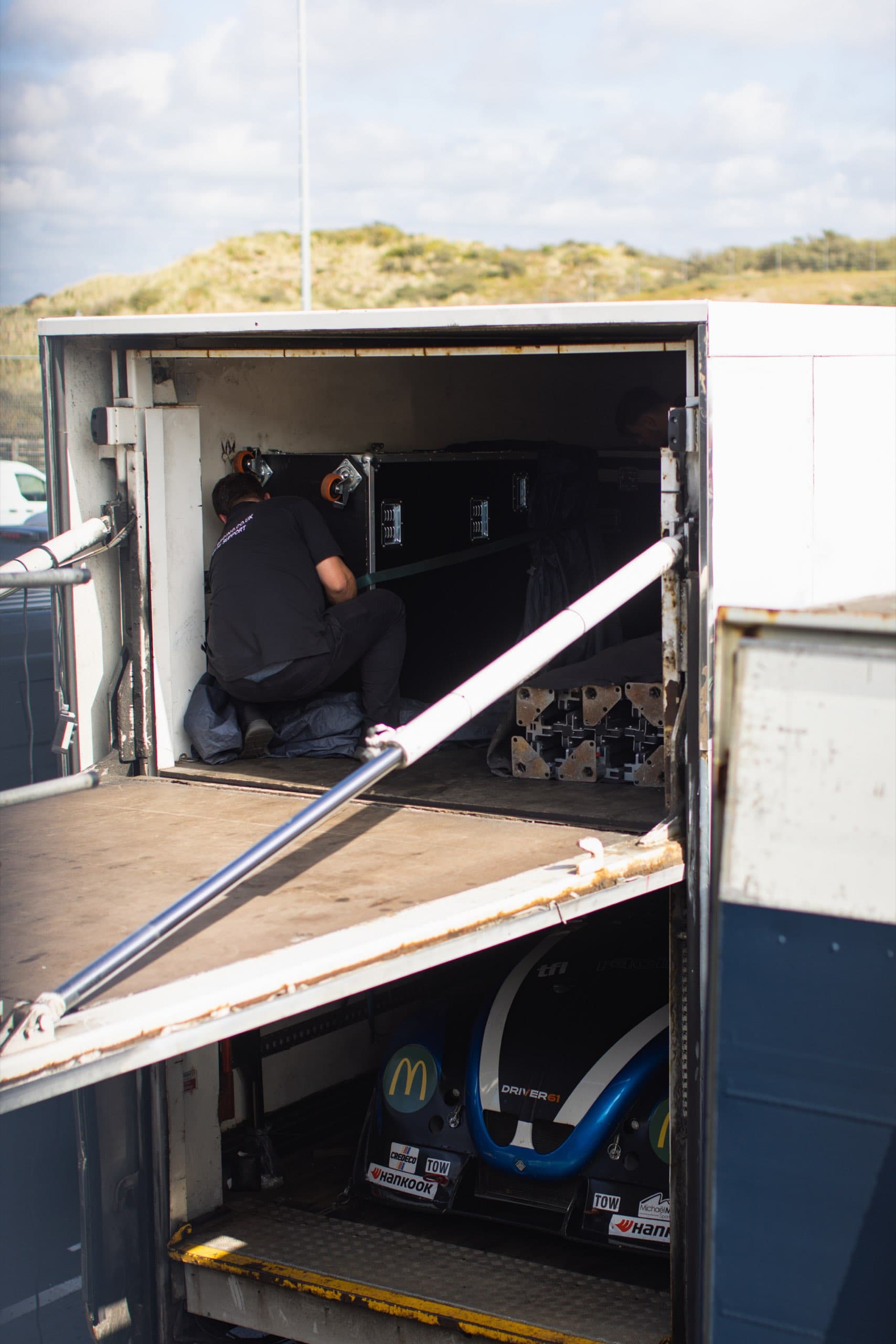 Geöffneter Anhänger mit Rennwagen im Fahrerlager
