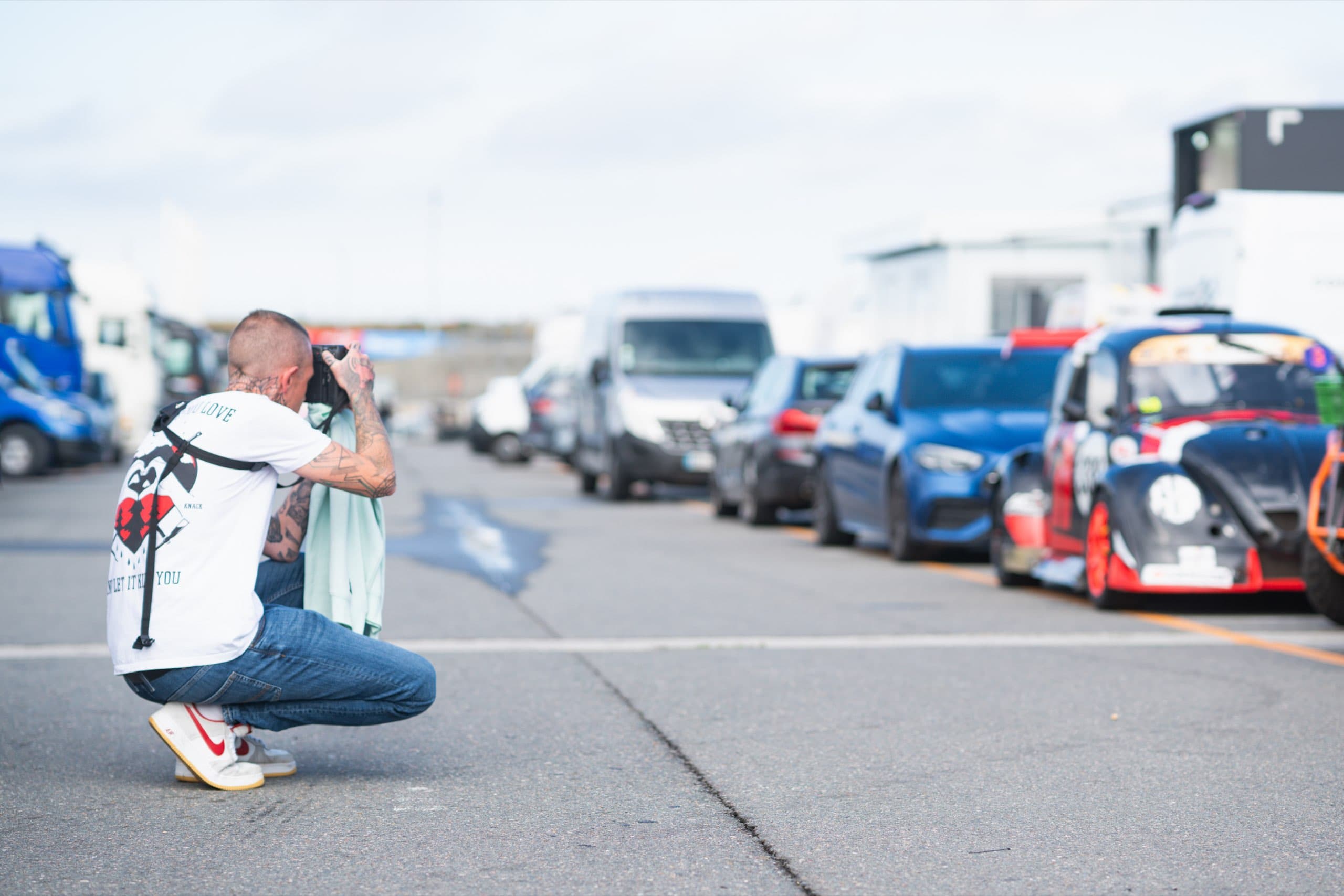 Daniel Boberg fotografiert in der Hocke im Fahrerlager
