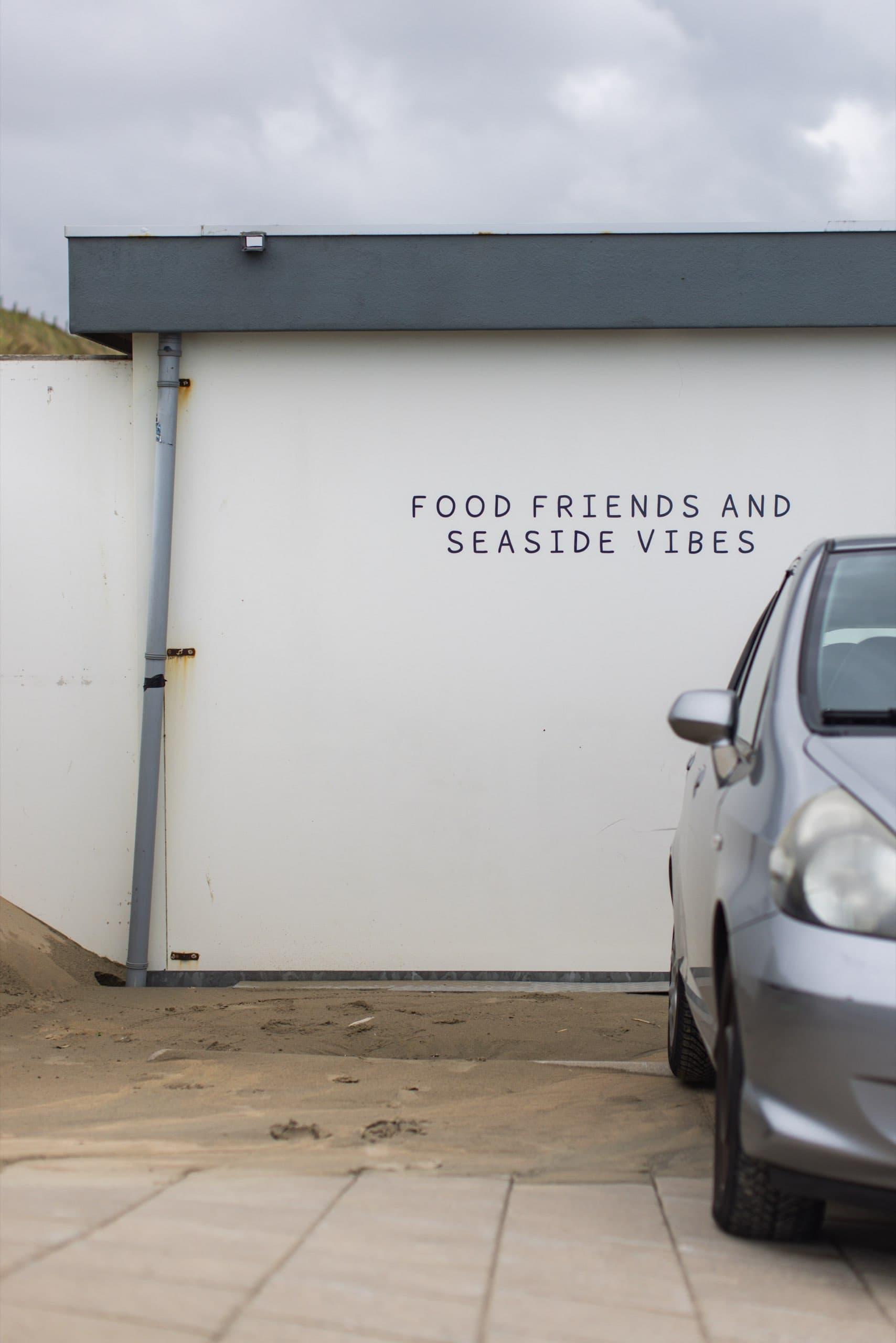 Strandbar-Wand mit der Aufschrift Food Friends and Seaside Vibes