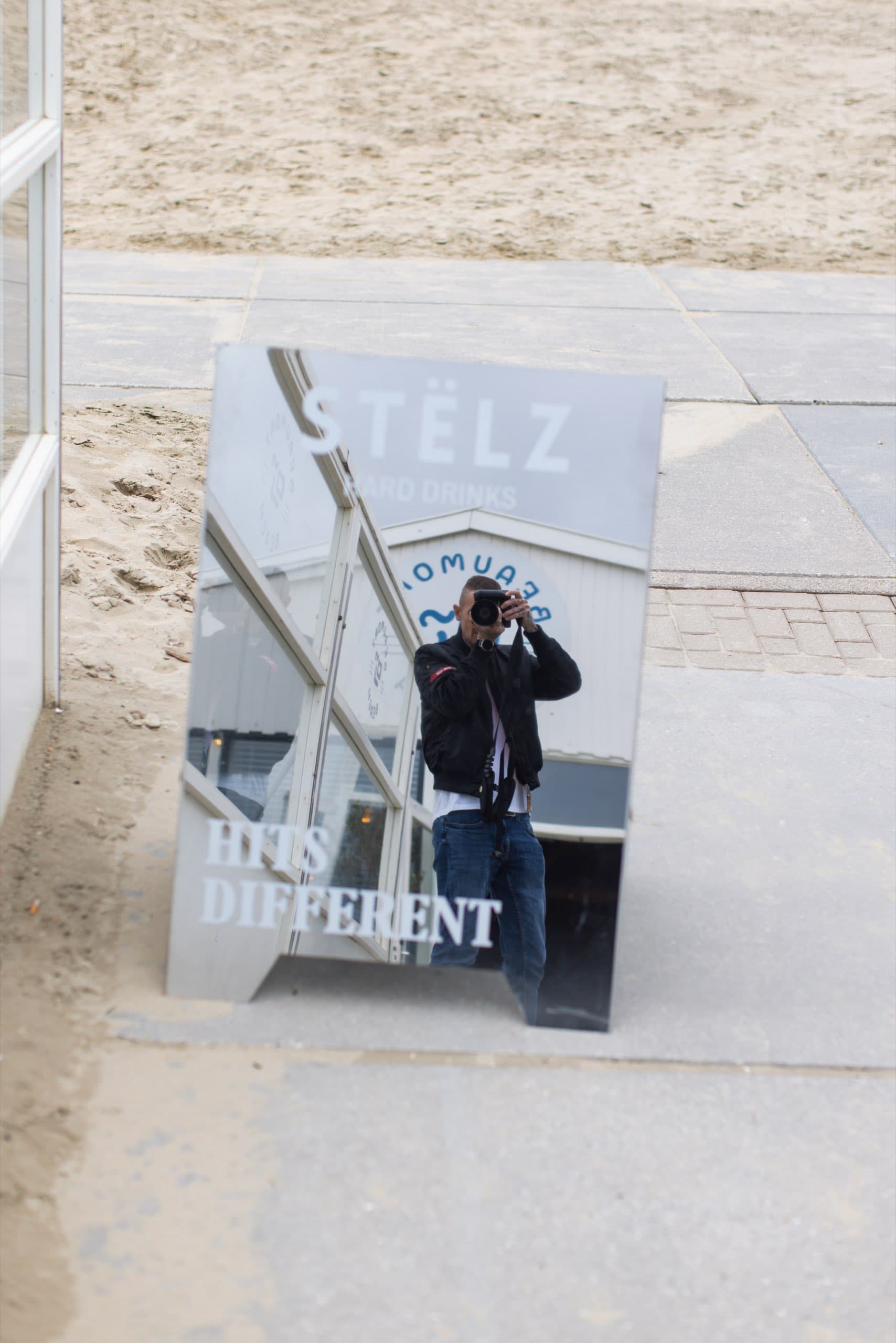 Spiegel am Strandaufgang mit einer fotografierenden Person