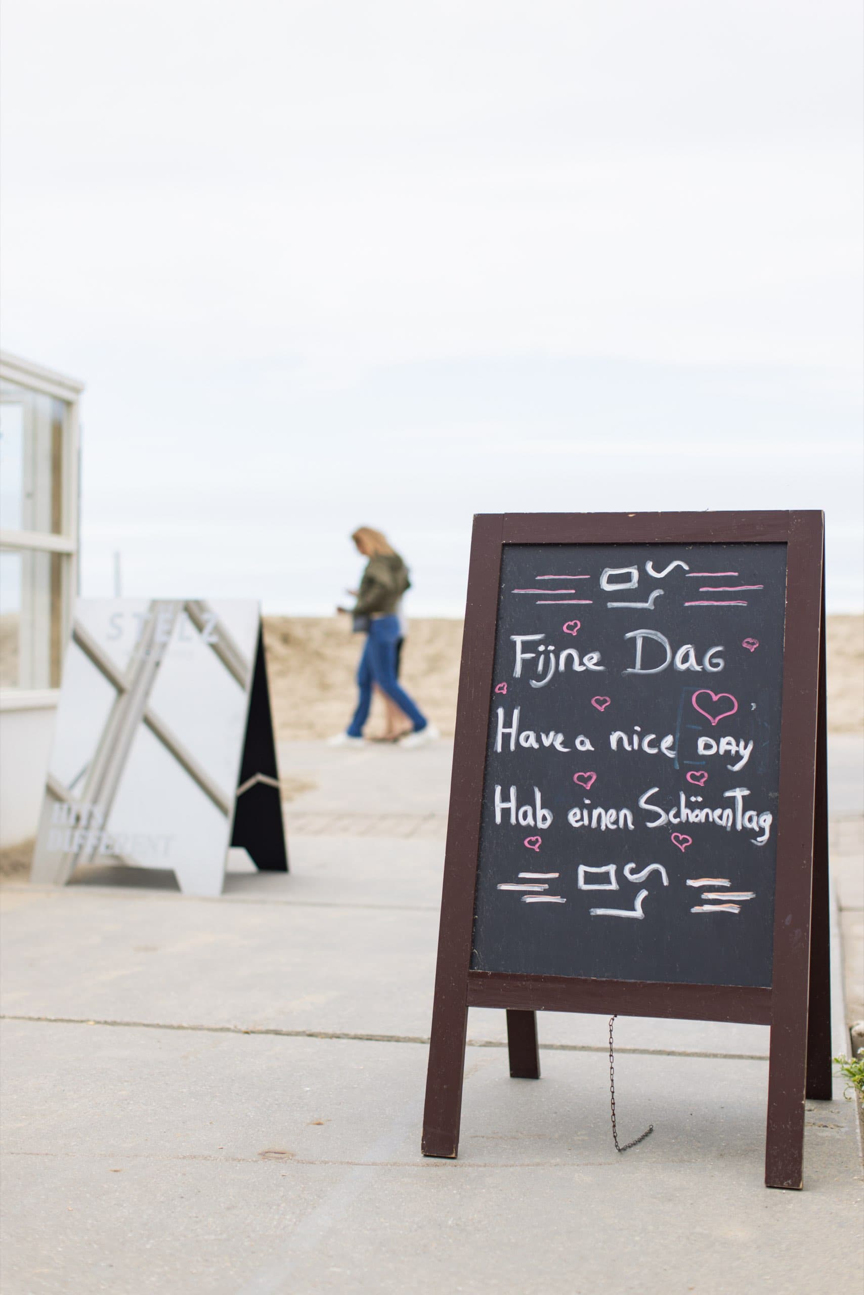 Kreidetafel mit Fijne Dag vor einem Strandpavillon
