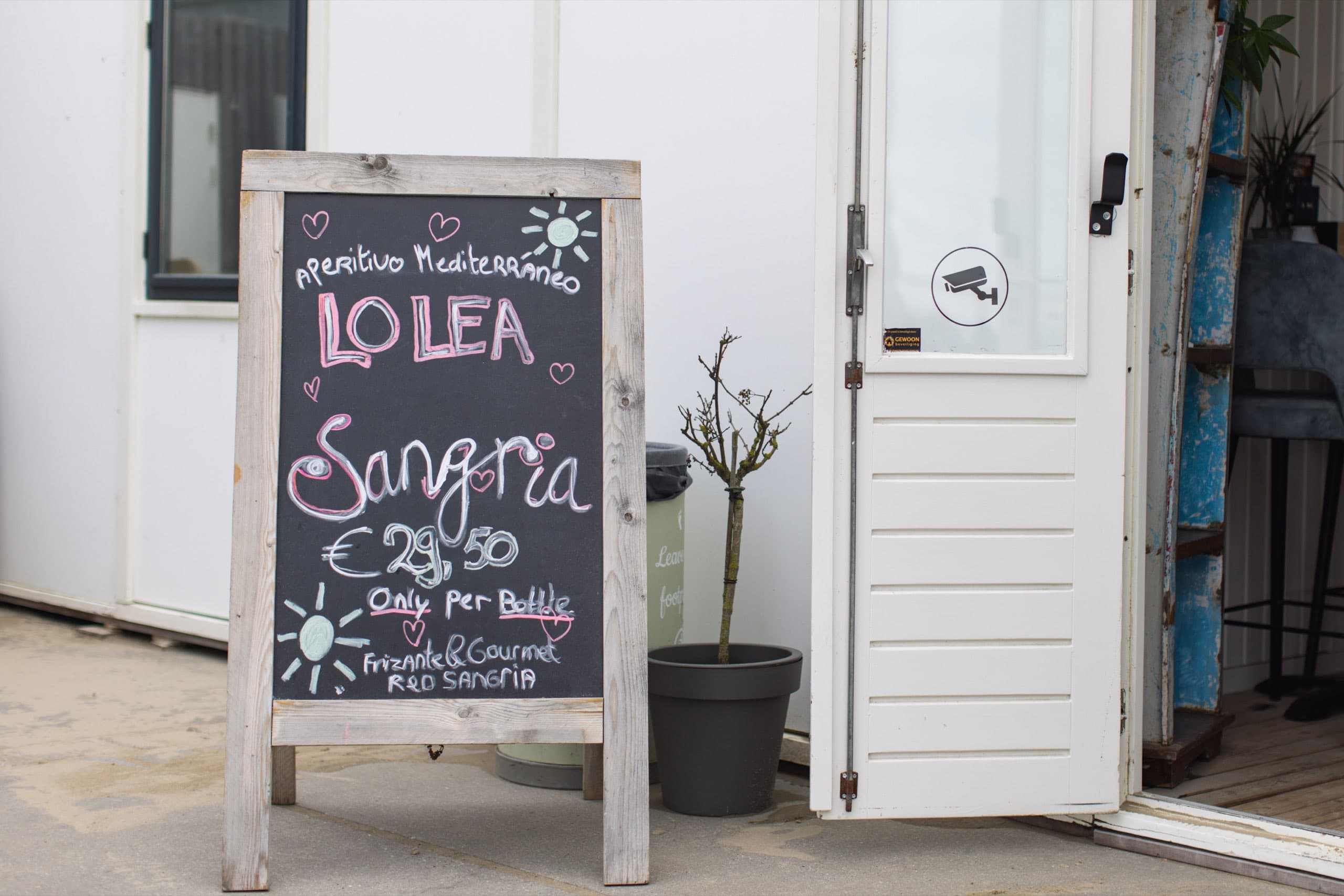 Kreidetafel mit Sangria-Angebot vor einem Strandlokal