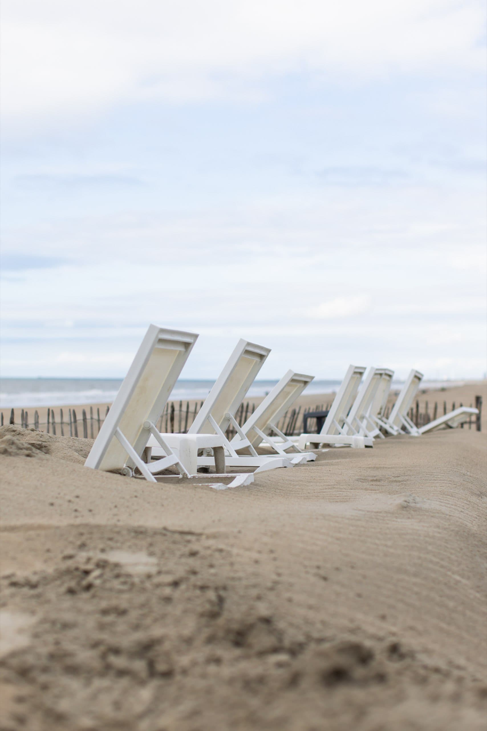 Umgeklappte Strandliegen im Sand
