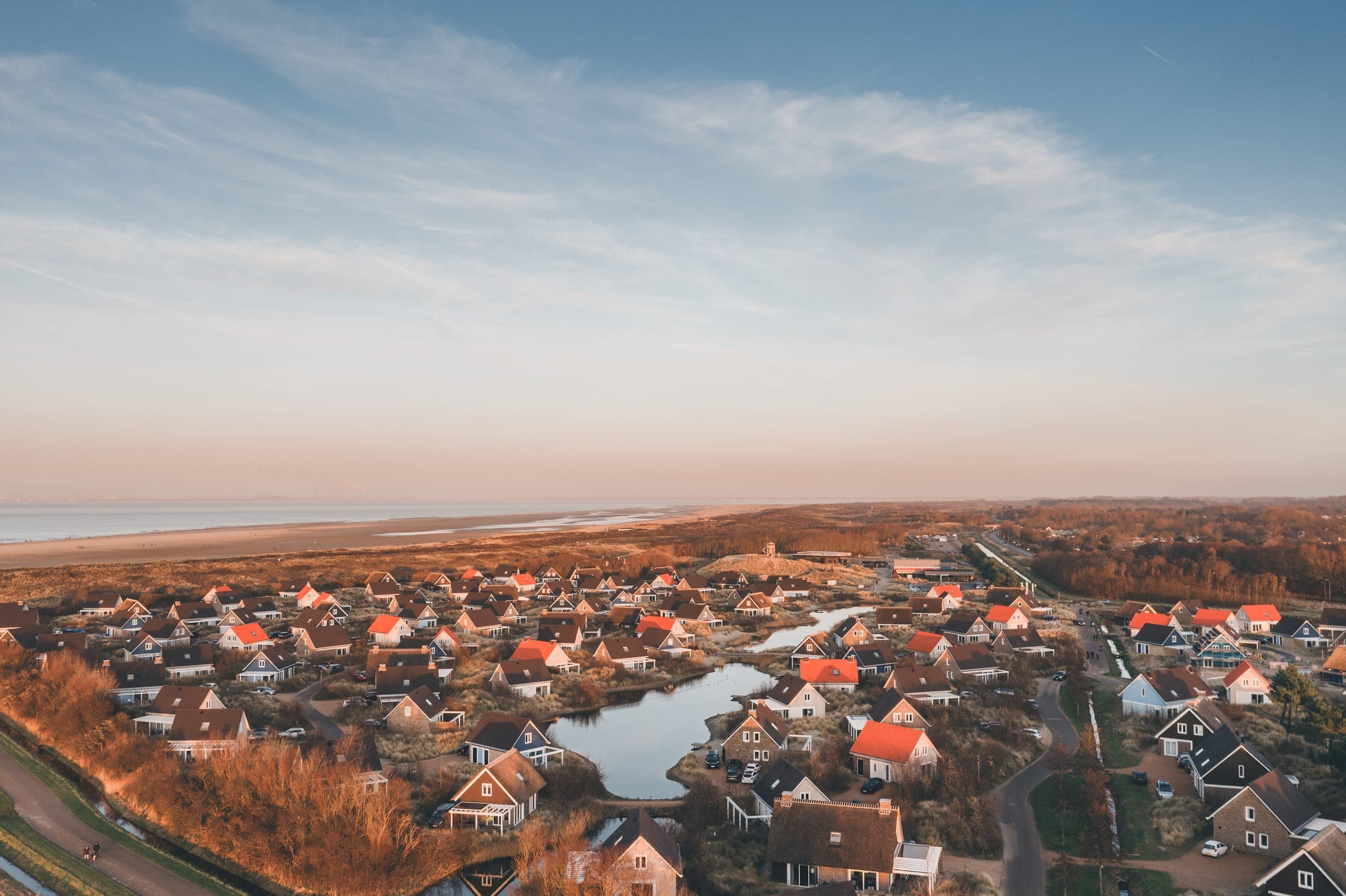 Ferienhaussiedlung mit Teich und Dünen aus der Luft