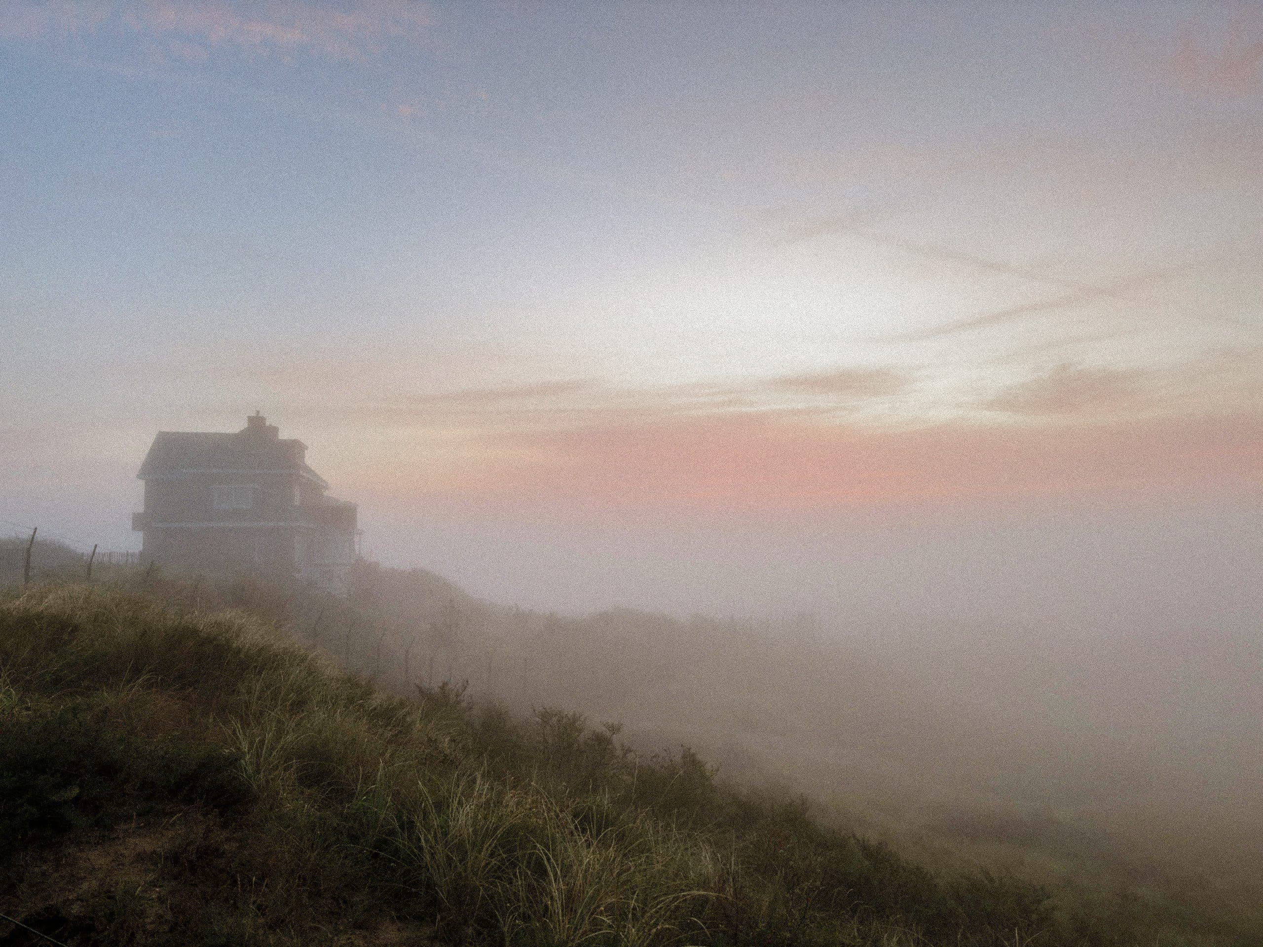 Villa im Nebel über den Dünen im Morgenrot